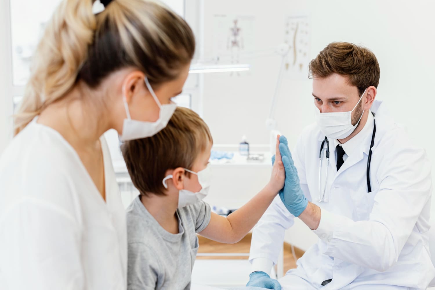 Doctor chocando la mano con un niño