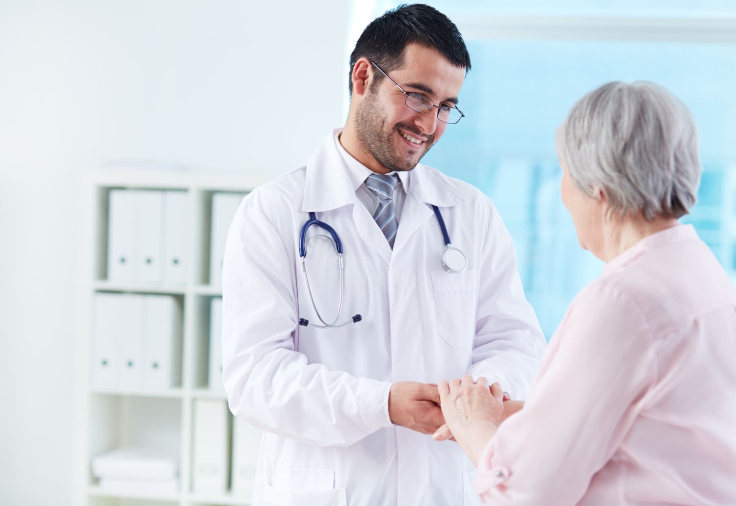 Mujer de la tercera edad saludando a un doctor